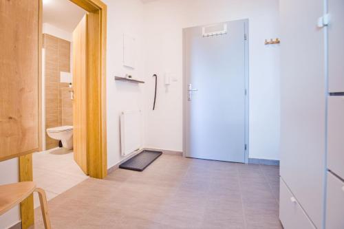 a bathroom with a door leading to a toilet at Apartmány Dolce Vita Lipno 511-5 s výhledem na jezero in Lipno nad Vltavou