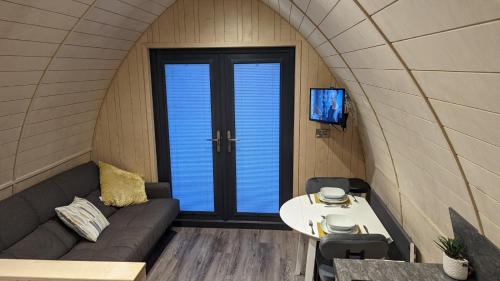 a small living room with a couch and a table at Ashberry Glamping in York