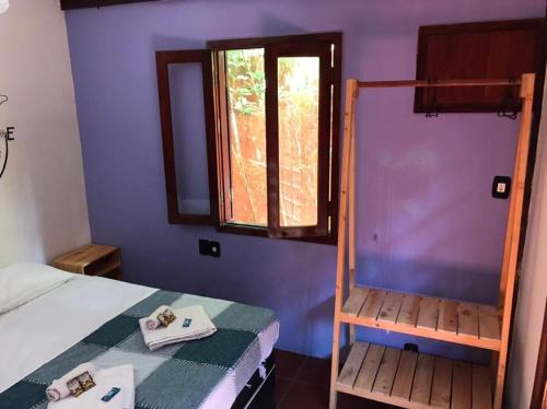 a small bedroom with a bed and a window at Numa Boa HOSTEL Búzios in Búzios