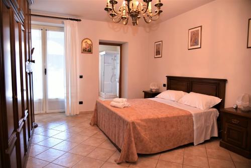 a bedroom with a bed and a chandelier at A CASA DI ANNA in La Morra
