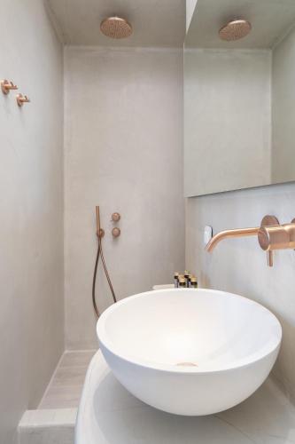 a white bath tub in a white bathroom at Airth Santorini Suites in Firostefani