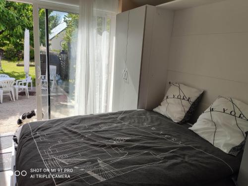 a bed with a black comforter in a bedroom at Studio Les Tilleuls in Amboise