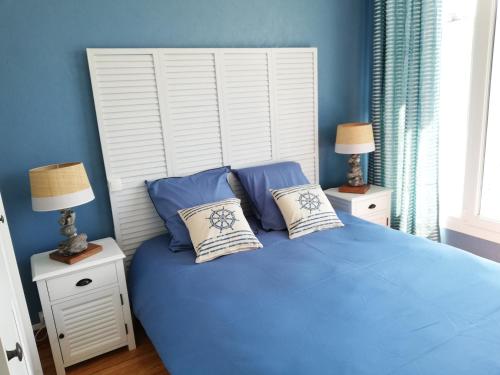 een blauwe slaapkamer met een groot bed met 2 lampen bij Au Bigorneau Langoureux in Criel-sur-Mer