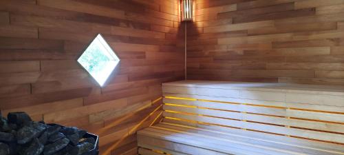 a sauna with a wooden wall and a window at Mid-Wales Farmhouse, swimming pool, tranquil countryside views, sleeps 14 in Meifod