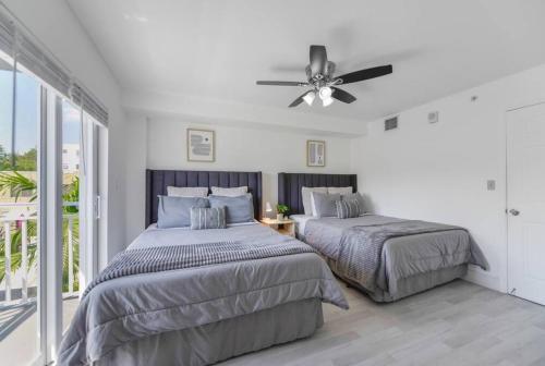 sypialnia z 2 łóżkami i wentylatorem sufitowym w obiekcie Splendid Location Apt close to Brickell & Marlins Park w Miami