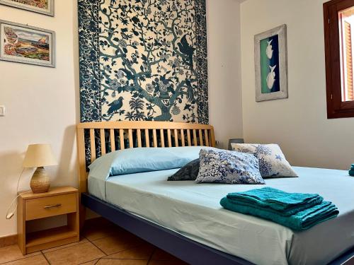 una camera da letto con letto con lenzuola blu e cuscini blu di Villa Antonella a San Teodoro
