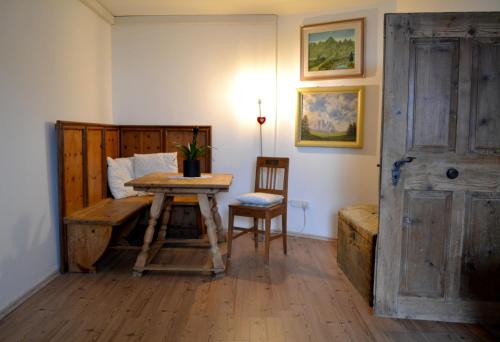 a bedroom with a bed and a table and a chair at Urige Ferienwohnung Steiger- Alloggio unico Steiger in Bressanone