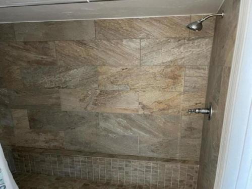 a bathroom with a shower with a stone wall at Inn at Camachee Harbor View 23 in Saint Augustine