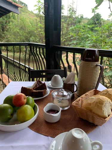een tafel met brood en een bord eten erop bij Pousada Villa Tropea - Fazenda Chapadão in Serra Negra