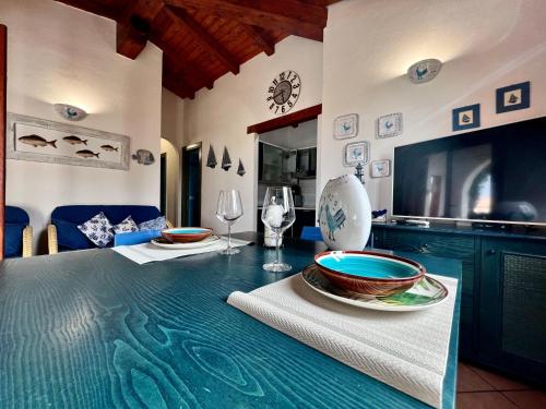 una cucina con tavolo, piatti e bicchieri da vino di Villa Antonella a San Teodoro