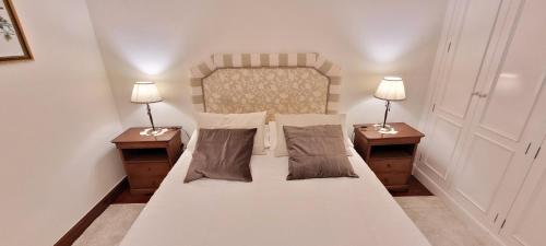 Un dormitorio con una cama grande con dos mesitas de noche. en Apartamento Lujo WiFi Algorta Getxo, en Getxo