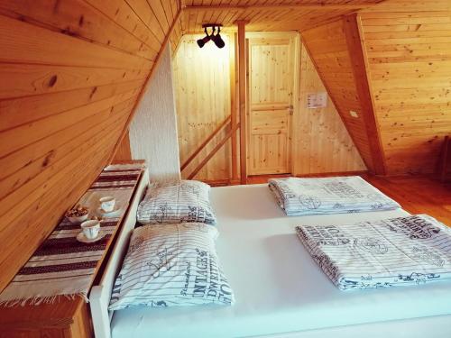 a bedroom with two beds in a wooden cabin at Challet Bella in Poljanica Bistranska