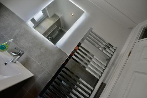 a bathroom with a staircase next to a sink at TorquayTownhouse with Hot Tub 200m from Beach - Free WiFi Sky Glass in Torquay