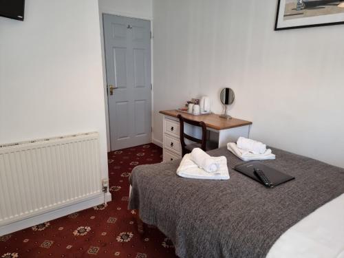a room with a bed and a table with towels on it at The Cameo in Blackpool