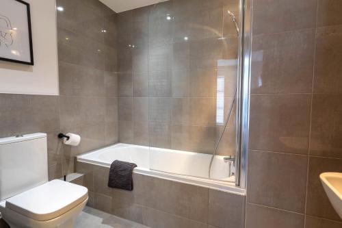 a bathroom with a tub and a toilet and a shower at Orchard Point in Southampton