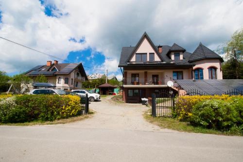a house with a car parked in front of it at HELENOWO in Lutowiska