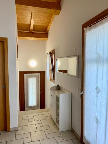 a bathroom with a sink and a door with a mirror at Casa Al Piazzol in Alano di Piave
