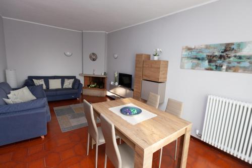 a living room with a wooden table and a blue couch at Casa di Dario in Diano dʼAlba