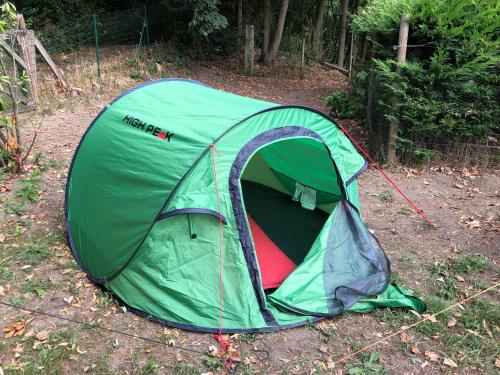 a green tent is set up on the ground at Tents @ Tomorrowland in Rumst