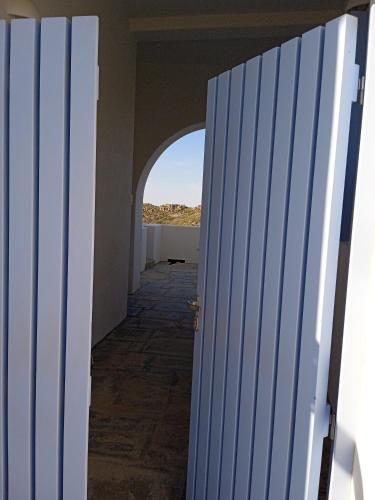 an open door to a hallway with a view of the ocean at Stilvi Milos in Plaka Milou