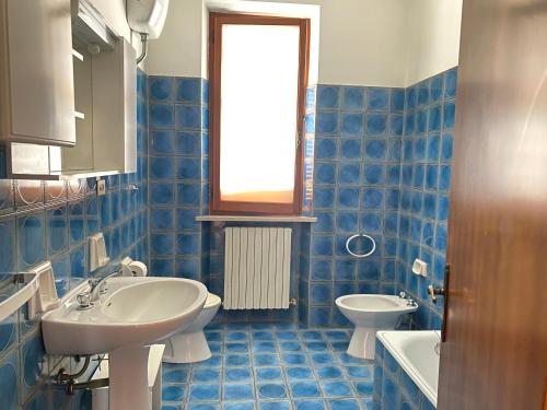 un bagno piastrellato blu con lavandino e WC di Alice a Numana