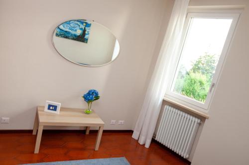a room with a table and a mirror and a window at Casa di Dario in Diano dʼAlba