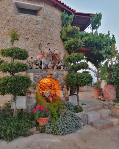 a garden with a fire place in the side of a building at Traditional Windmill-Milos in Kroústas
