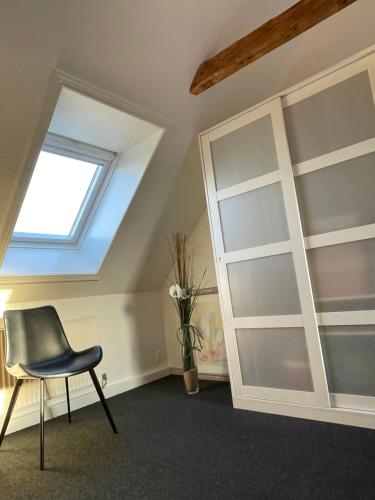 a room with a chair and a window at Sleep In Brande - Close By Herning, Legoland, Givskud Zoo in Brande