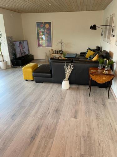 a living room with a black couch and a table at Sleep In Brande - Close By Herning, Legoland, Givskud Zoo in Brande