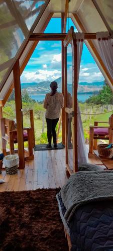 a woman standing in a room with a window at Dante Glamping in Guatavita