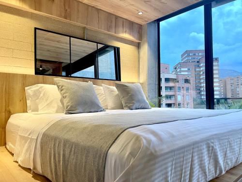 a bedroom with a large bed with a large window at beminimal Hotel in Medellín