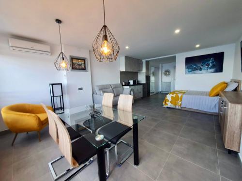 a living room with a dining table and a bedroom at Playa Poniente Benidorm in Benidorm