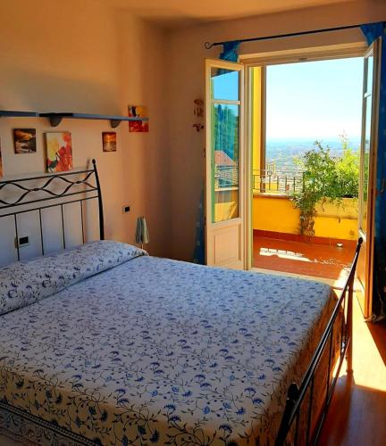 een slaapkamer met een bed en een groot raam bij Casa Marta in Massa