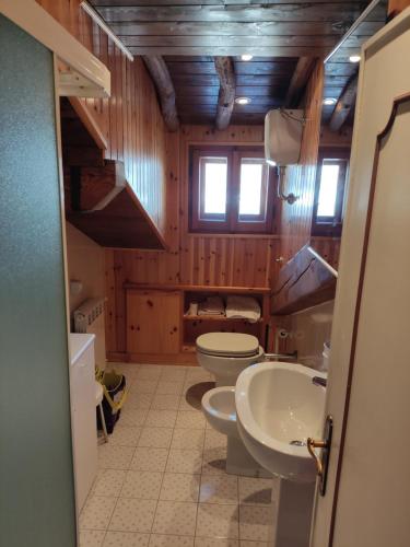 a bathroom with three toilets and two sinks in it at Stefano Home Abetone in Abetone