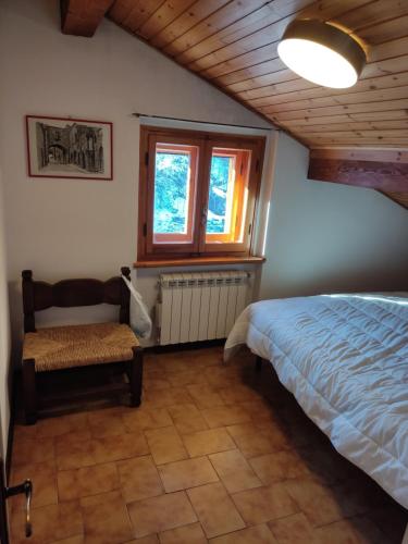 アベトーネにあるStefano Home Abetoneのベッドルーム1室(ベッド1台、窓、ベンチ付)