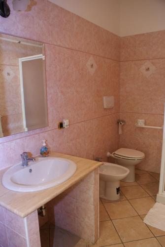 a bathroom with a sink and a toilet at B&B Al Porto in Marta