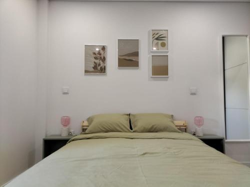 a bedroom with a bed with three pictures on the wall at Casa da Alfândega em Vila do Conde in Vila do Conde