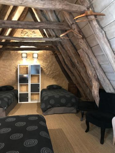 圣西普里安Gîte du Meynet的有两张床和一扇窗户的阁楼房间