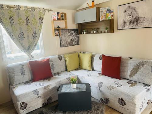 a living room with a couch with colorful pillows at Coeur Des Sables in Saint-Julien-en-Born