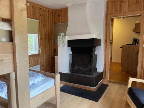 a room with a fireplace in a room with a bed at Dalsvallen in Sveg