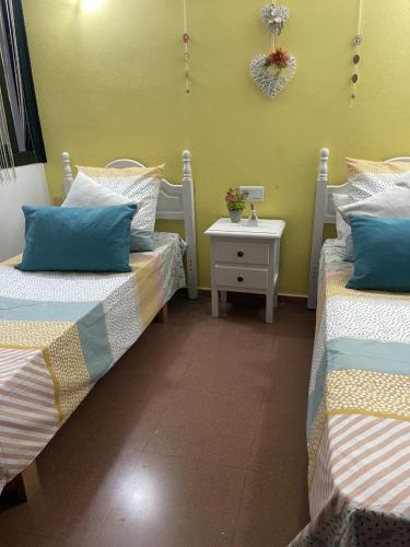 a room with two beds and a side table at Cala´n Bosch in Cala en Bosc