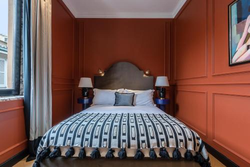 a bedroom with a large bed with orange walls at The Couper Sant'Andrea in Milan