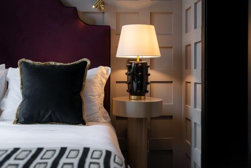 a bedroom with a bed and a lamp on a table at The Couper Sant'Andrea in Milan