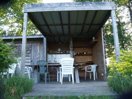 une table et des chaises en bois sur une terrasse en bois dans l'établissement camping chez l'habitant, à Noyal-Muzillac