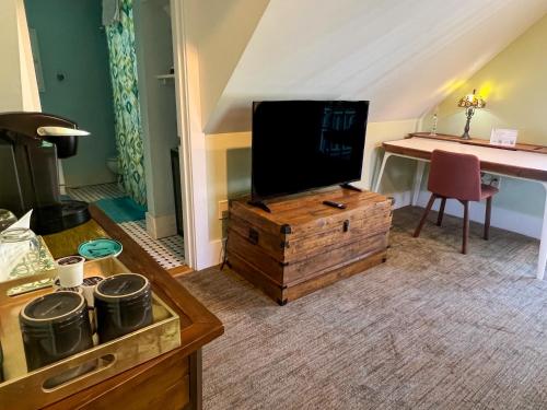 a living room with a flat screen tv on a wooden chest at Inn at Cook Street in Provincetown