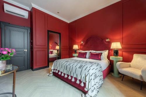 a red bedroom with a bed and a chair at The Couper Sant'Andrea in Milan