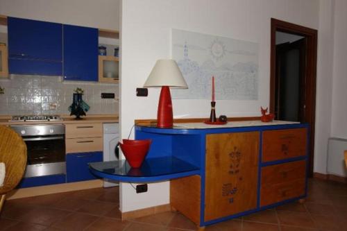 a kitchen with a blue table with a lamp on it at Casa Roberta in Alghero