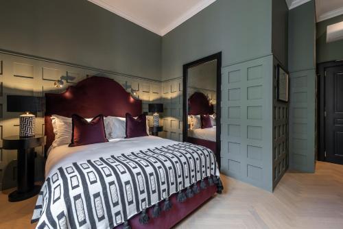 a bedroom with a large bed and a large mirror at The Couper Sant'Andrea in Milan