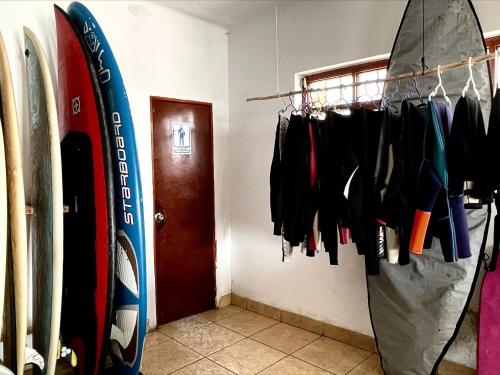 um quarto com uma prateleira de pranchas de surf e uma porta em Totora Surf Hostel em Huanchaco