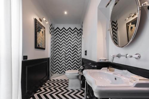 a bathroom with a sink and a toilet and a mirror at The Couper Sant'Andrea in Milan